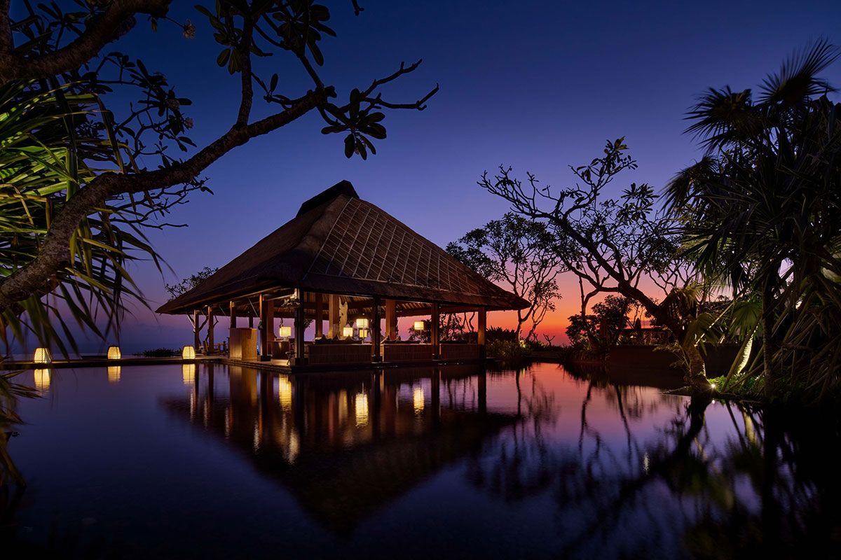 Balinese pavilion reflected in still water at dusk