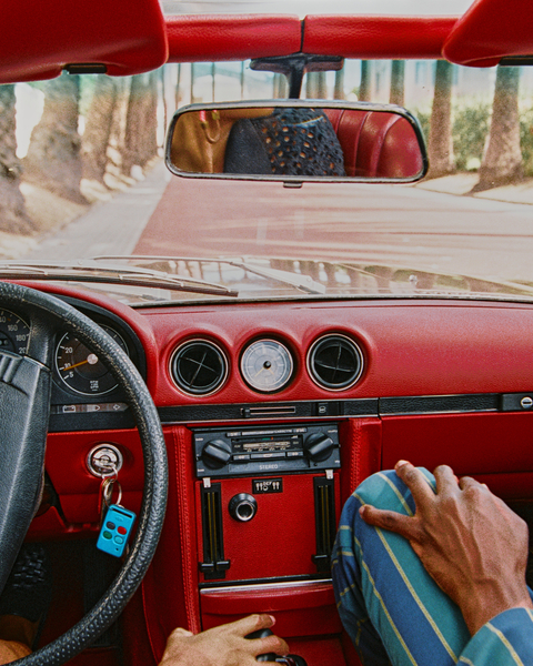 View from inside a vintage convertible driving beneath palm trees
