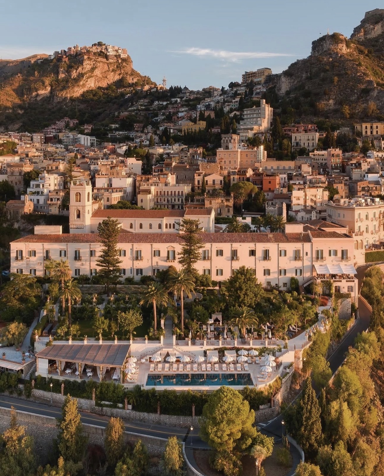 Taormina hillside and a former convent hotel with gardens at sunrise