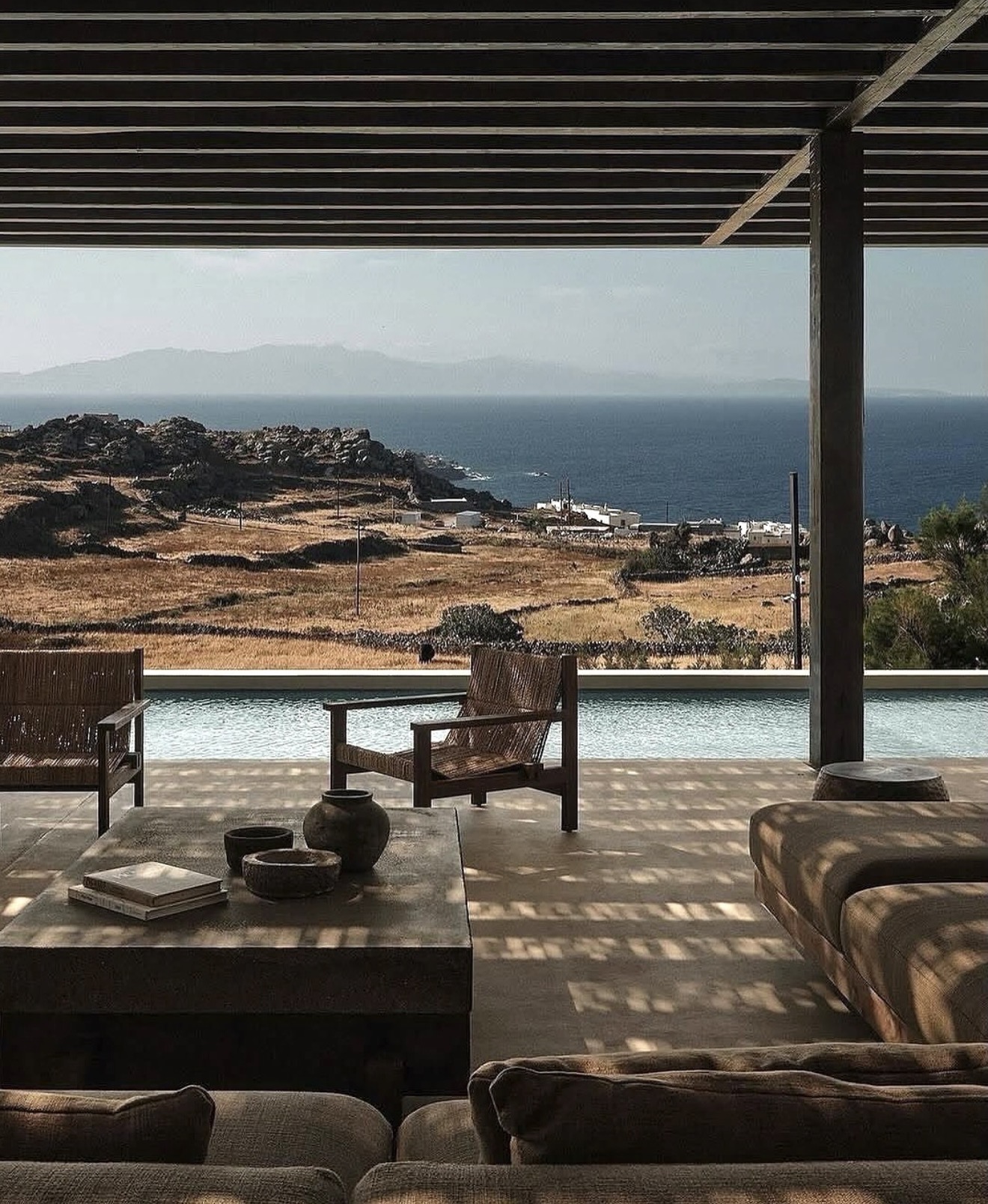 Shaded pergola lounge above an infinity pool looking out to the Aegean