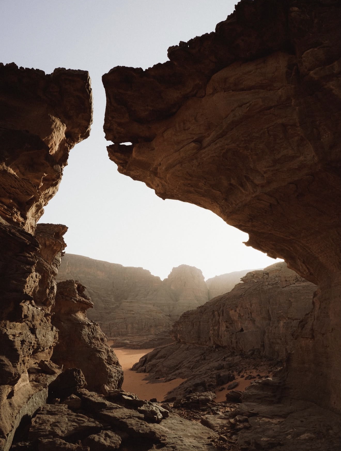 Sunlit sandstone canyon opening onto a remote desert valley