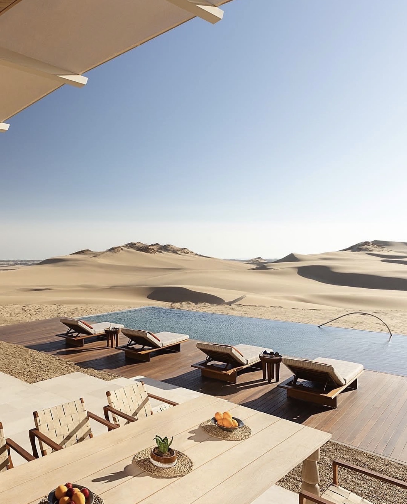 Minimal desert retreat and infinity pool facing untouched dunes