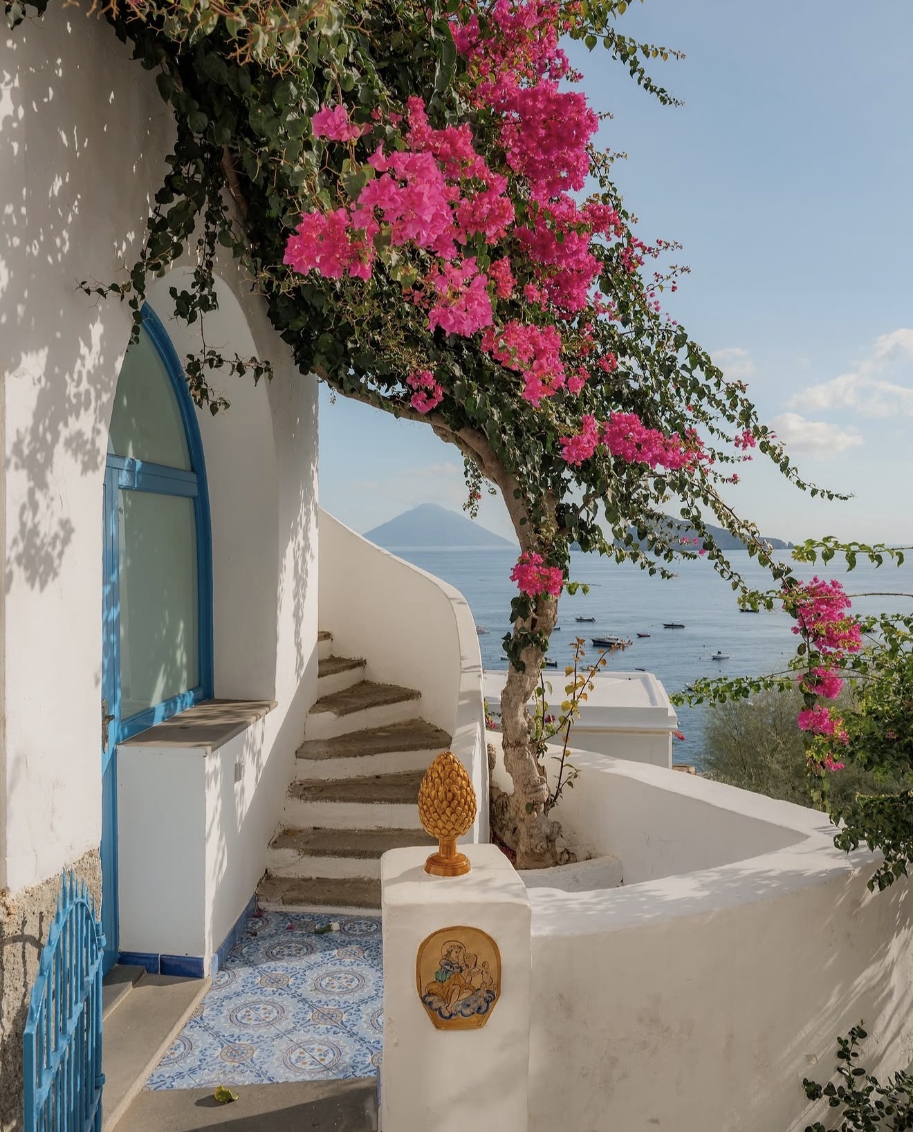 Whitewashed steps and bougainvillea on Panarea looking out to Stromboli across the sea