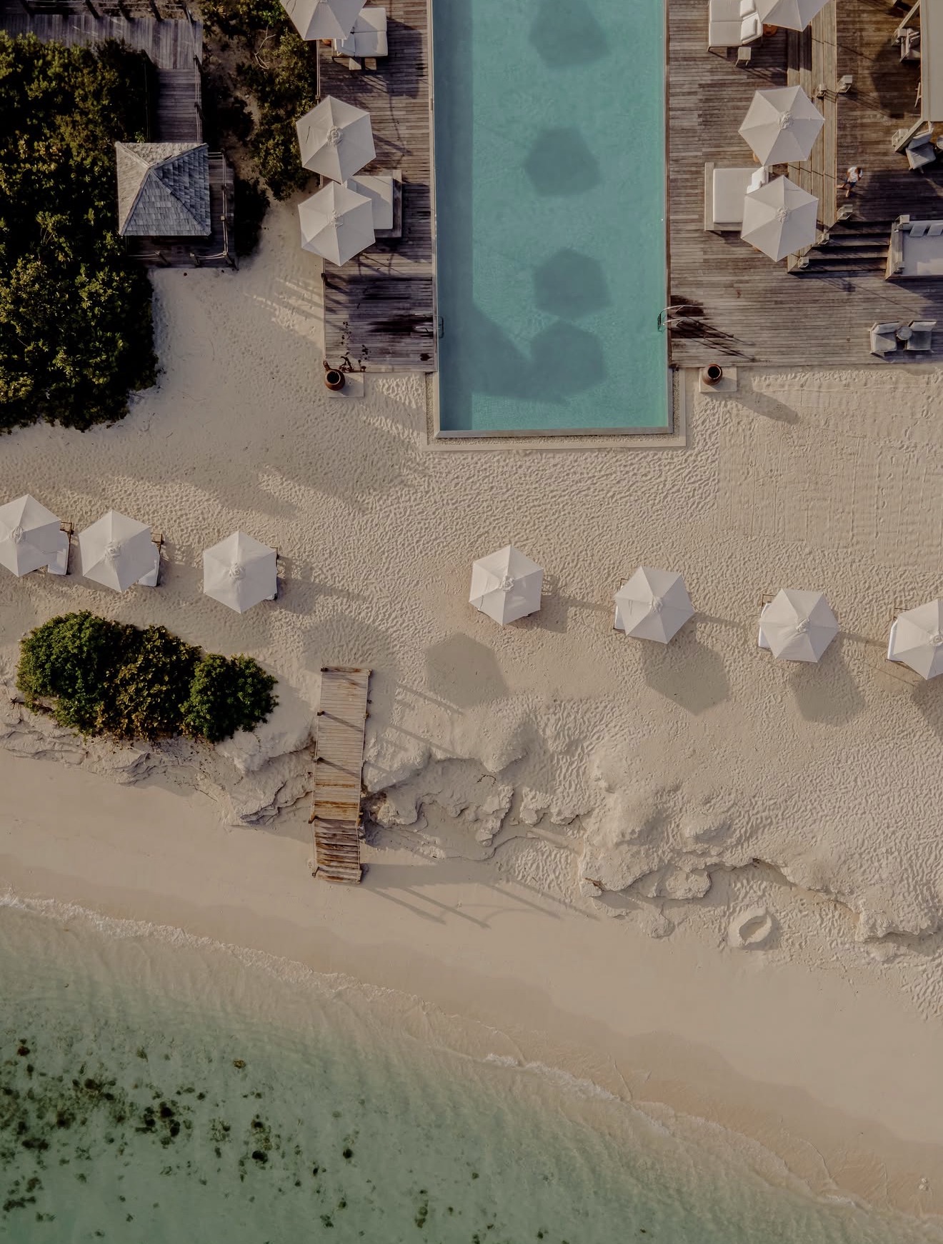 Aerial view of a quiet pool and white-sand Caribbean beach