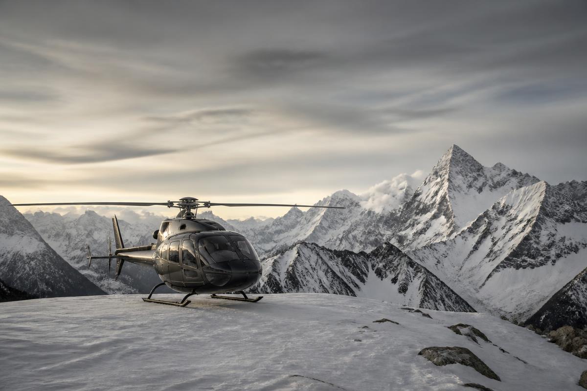 Helicopter on a high Andean snowfield with peaks beyond
